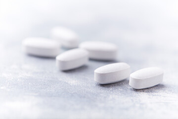 Amino acids tablets on wooden background. Soft focus. Close up	