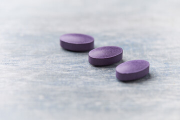 Lutein tablets. Dietary supplement on wooden background. Soft focus. Close up. Copy space
