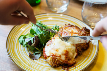 Cutting into crispy chicken parmigiana
