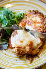 Cutting into crispy chicken parmigiana