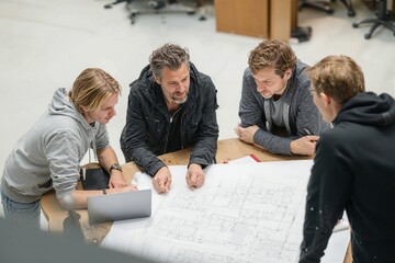 Team of architects discussing building plans at a table