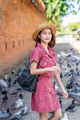 Young Asian woman exploring Tha Phae Gate, a heritage landmark in Chiang Mai, Thailand. Female...