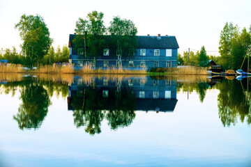 Evening, evening sky and calm on spring river, forest and village, quiet evening romantic nature....
