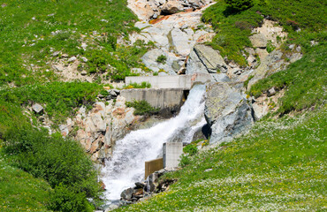 Scenic view of stream with rocks and splashing water at Lötschental Valley in the Swiss Alps on a...