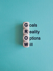 GROW symbol. Concept word GROW Goals, reality, options, will on wooden cubes. Beautiful blue...