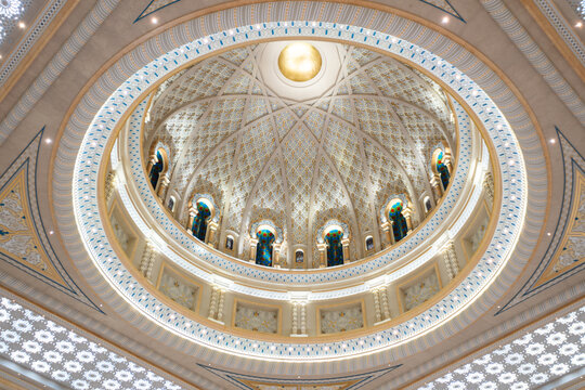 Ornate architectural dome with intricate patterns and stained glass windows, featuring elaborate geometric designs in a grand, luminous setting.