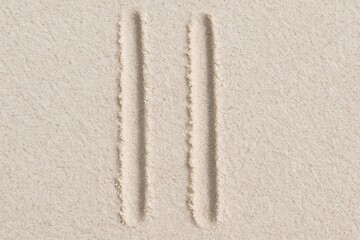 Minimalist sand artwork showcasing two parallel lines creating a simple, textured pattern and sandy beach background.