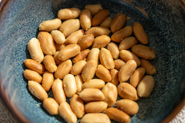 Bowl of roasted salted peanuts close-up