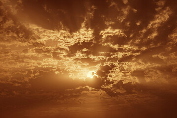 Captivating sunset with dramatic clouds and radiant sunbeams breaking through, creating a warm, golden atmosphere in the sky