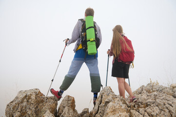 Couple Hiking on Rocky Terrain with Backpacks in Overcast Weather Depicting Outdoor Adventure and...