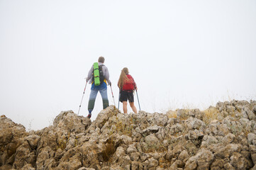 Couple Hiking on Rocky Terrain in the Fog Exploring Nature's Beauty
