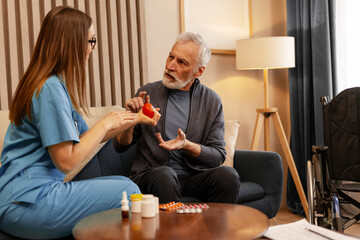 Nurse assisting senior man with hand physical therapy at home