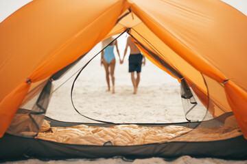 Romantic Couple Holding Hands By Orange Tent On Beach