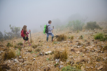 Two Hikers Exploring a Misty Mountain Landscape in Nature
