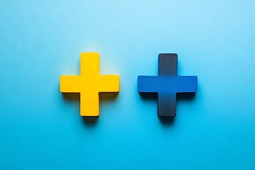 Two Colorful Plus Signs A Yellow Plus and a Blue/Black Plus on Blue