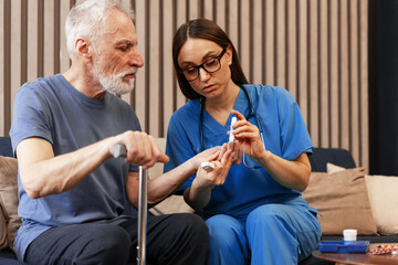 Nurse measuring blood glucose level of senior man using lancet pen