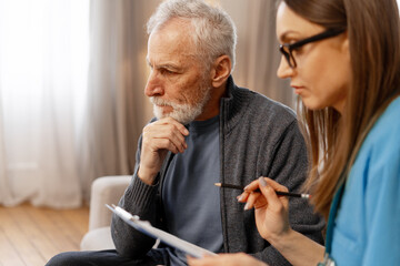 Senior man discussing medical history with doctor at home visit