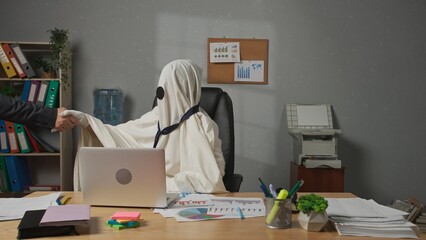 Halloween businessman ghost in white sheet sits at office desk works on laptop, meets with partner doing handshake and greeting. Happy halloween business concept.