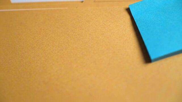Bright blue sticky note on a textured tan surface