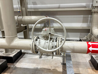 High-resolution image of an industrial piping system featuring a large manual valve with a handwheel