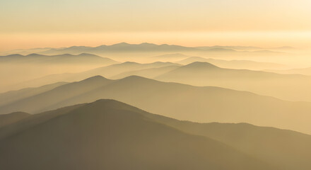 Misty Mountain Range at Sunrise with Golden Hues in the Sky	