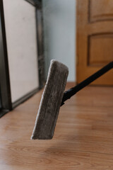 Close-up of steam mop releasing hot vapor during cleaning wooden floors, ensuring efficient and...