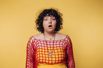 Surprise and shock expressed by a young woman against a vibrant yellow background during a fun...