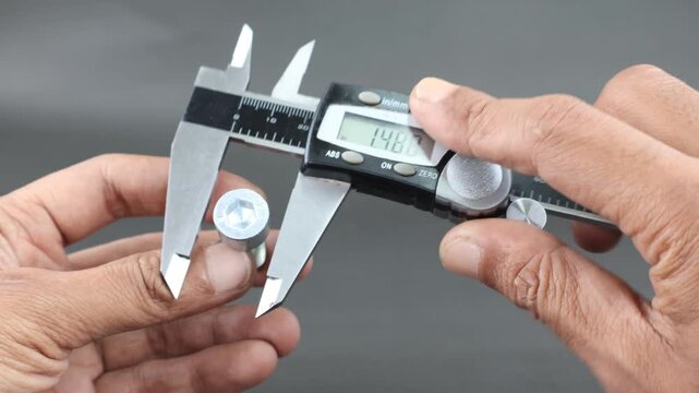 Hand measure diameter hex bolt using digital vernier caliper on black background. Universal tool for high-precision measurements of external and internal dimensions. Measurement tool.