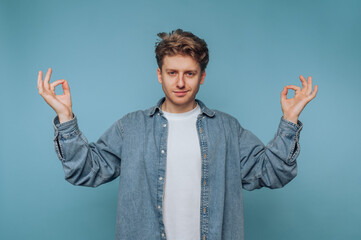 Young man practicing mindfulness in a calm studio setting, showcasing peace and balance with hand...