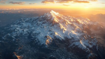 Fototapeta premium Majestic mountain peak bathed in golden sunrise light. Aerial view of snowy mountain range