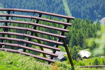 Mountain landscape with close up of metal avalanche protection at Lötschental Valley in the Swiss Alps on a sunny late spring day. Photo taken June 19th, 2025, Lötschental, Switzerland.