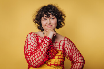 Creative portrait session featuring a person with curly hair dressed in a vibrant red netted...