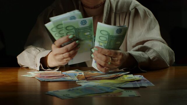 Counting 100 euro bills with stacks of money on the table