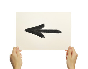 Hands holding a photograph with a black arrow on an isolated background. Direction to the left.