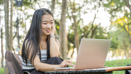 Happy freelancer working while sitting at park at park