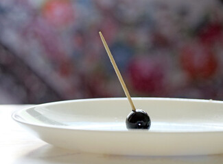 Simple Black Olive on Toothpick in White Dish - Elegant Appetizer Presentation