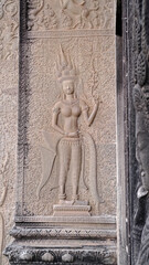 Detailed stone bas-relief of an apsara dancer carved on a temple wall in Angkor Wat, Cambodia. Traditional Khmer art and architecture.