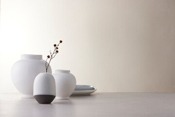 Elegant Korean table setting with traditional Korean bojagi gift wrapping for Chuseok, ceramic vase and fabric, tree branches.