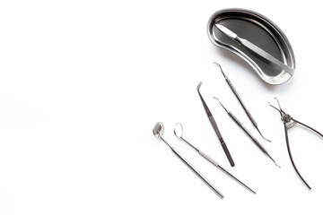 Many dental metal tools on white background. Professional Dentist desktop, top view