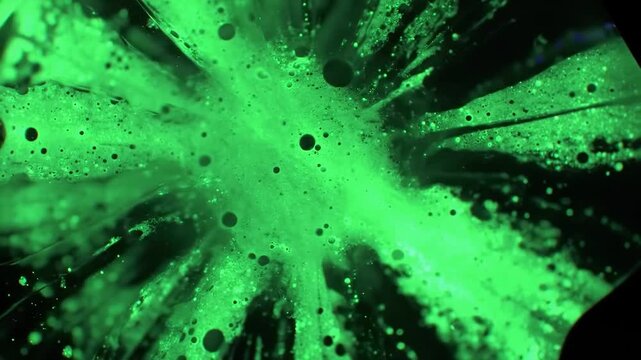 Close-up of luminescent green fluid with black bubbles
