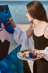 Young female artist paints vibrant canvas by seashore, capturing essence of creativity and...