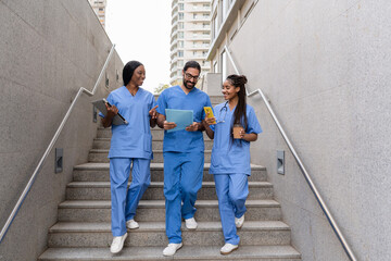 Obraz premium Multiracial medical students walking down hospital stairs