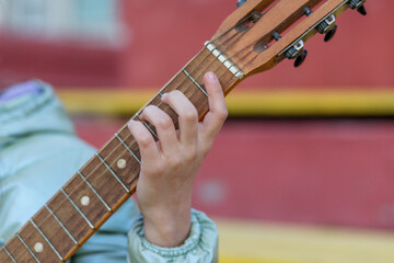 Fingers pressing guitar strings on fretboard