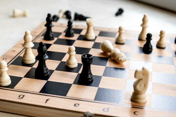 Checkmate. White king chess piece laying down on chessboard after checkmate