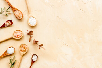 Beauty spa therapy cosmetics and wellness flat lay - sea salt in many spoons with flowers, top view