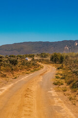 Scenic view of a vehicle on a dirt road against a Mountain background at Kedong in Naivasha, Rift Valley, Kenya 