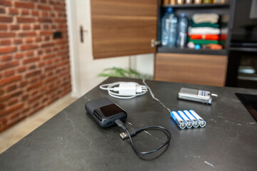 Emergency kit for power outage with power bank, batteries, portable radio and phone charger at...