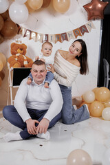 Family celebrates a young child's first birthday with decorations and smiles
