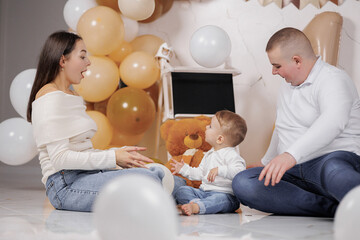 Family enjoys playtime during a toddler's birthday celebration in a decorated room