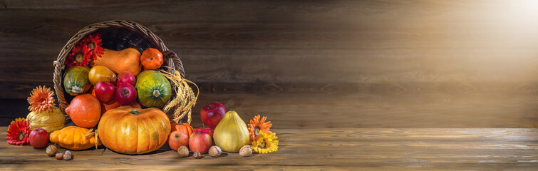 Thanksgiving day background with empty copy space. Pumpkin harvest in wicker basket. Squash, orange...